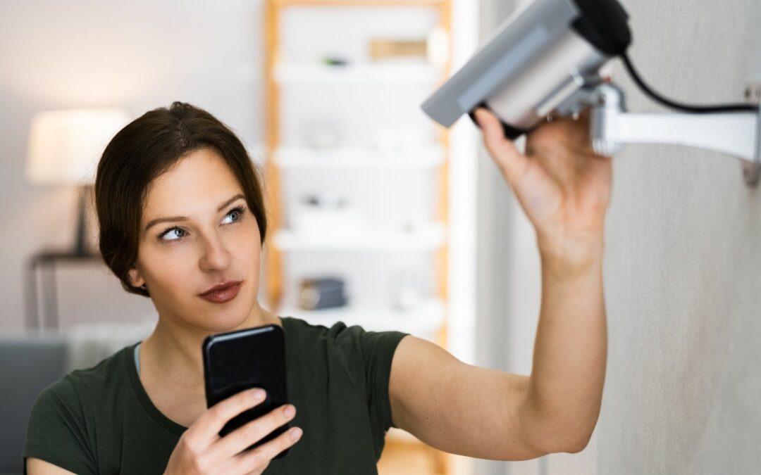 A woman checks the camera for her home security system.